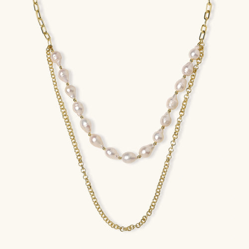 Layered gold chain necklace with organic baroque freshwater pearls and adjustable length on cream background